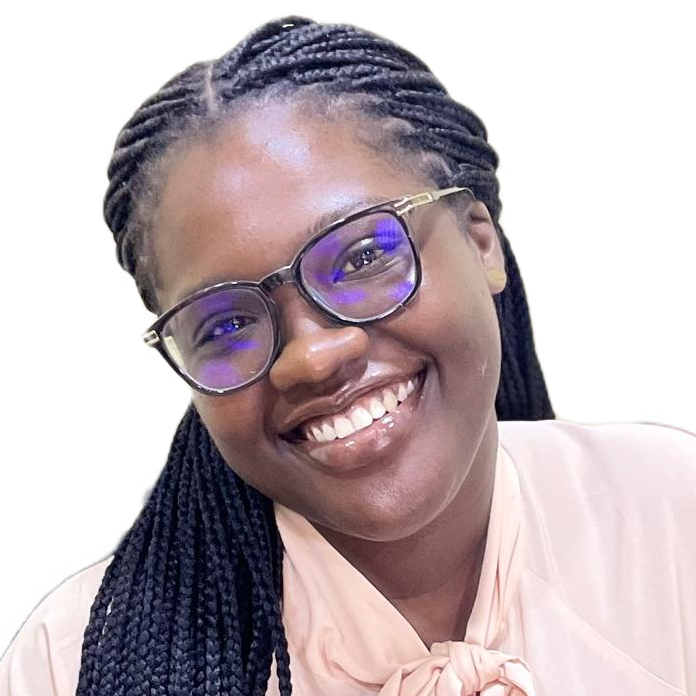 Smiling woman with long braids and glasses wearing a light-colored blouse with a bow.